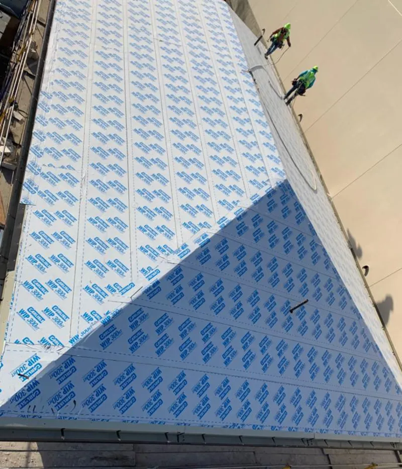 Professional roofers installing underlayment on a metal roof in Merritt Island